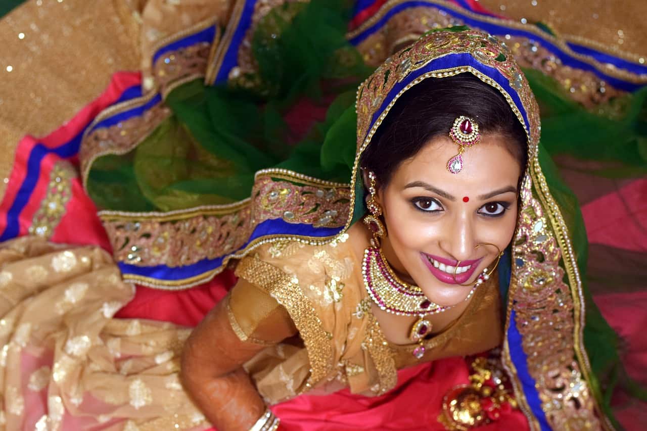An Indian woman wearing a traditional dress is smiling