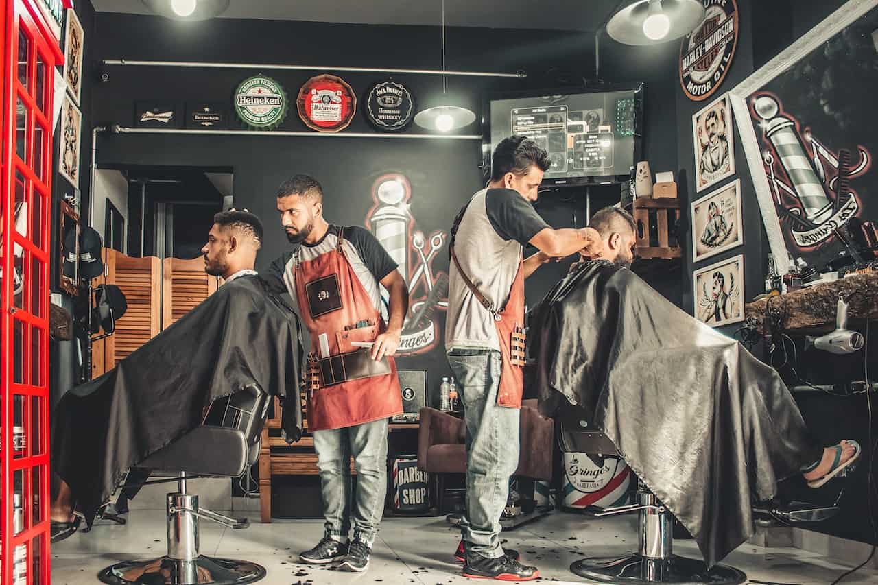 two barbers cutting hair in their shop