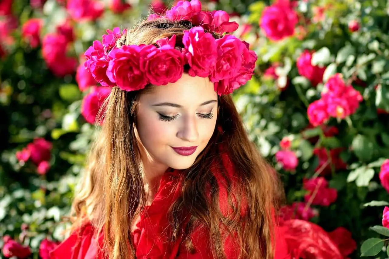 A beautiful woman is standing in a garden of flowers.