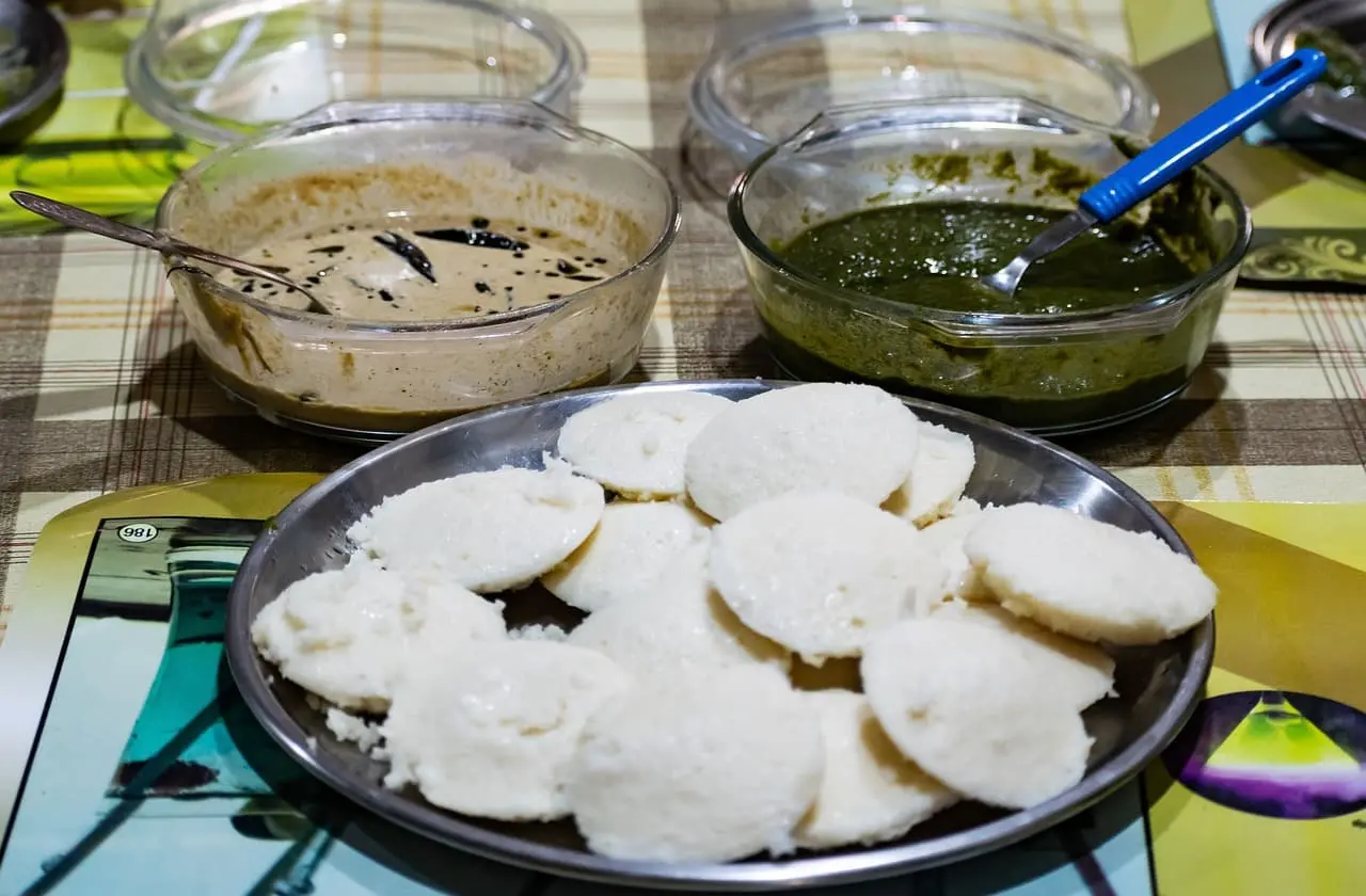 Idli topped with coconut chutney and green chutney