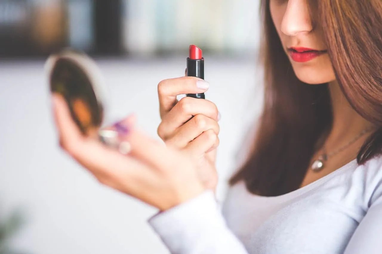 a beautiful woman applying lipstick