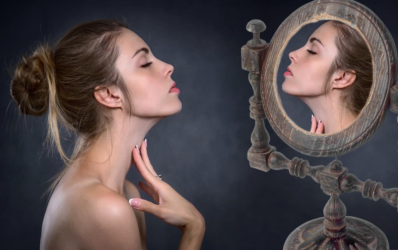 a woman looking at herself in the mirror